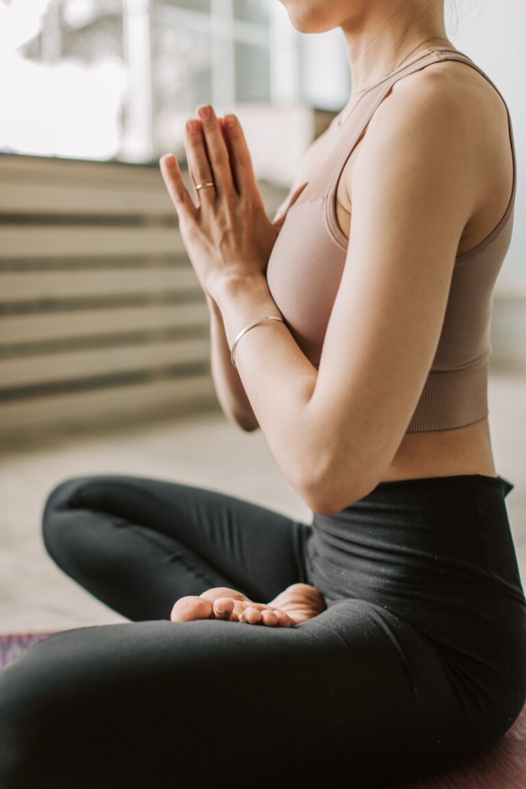 Donna con mani e braccia congiunte pratica Pilates e meditazione